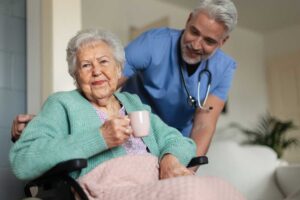 Older couple sharing a quiet assisted living apartment while a caregiver reviews a daily care plan